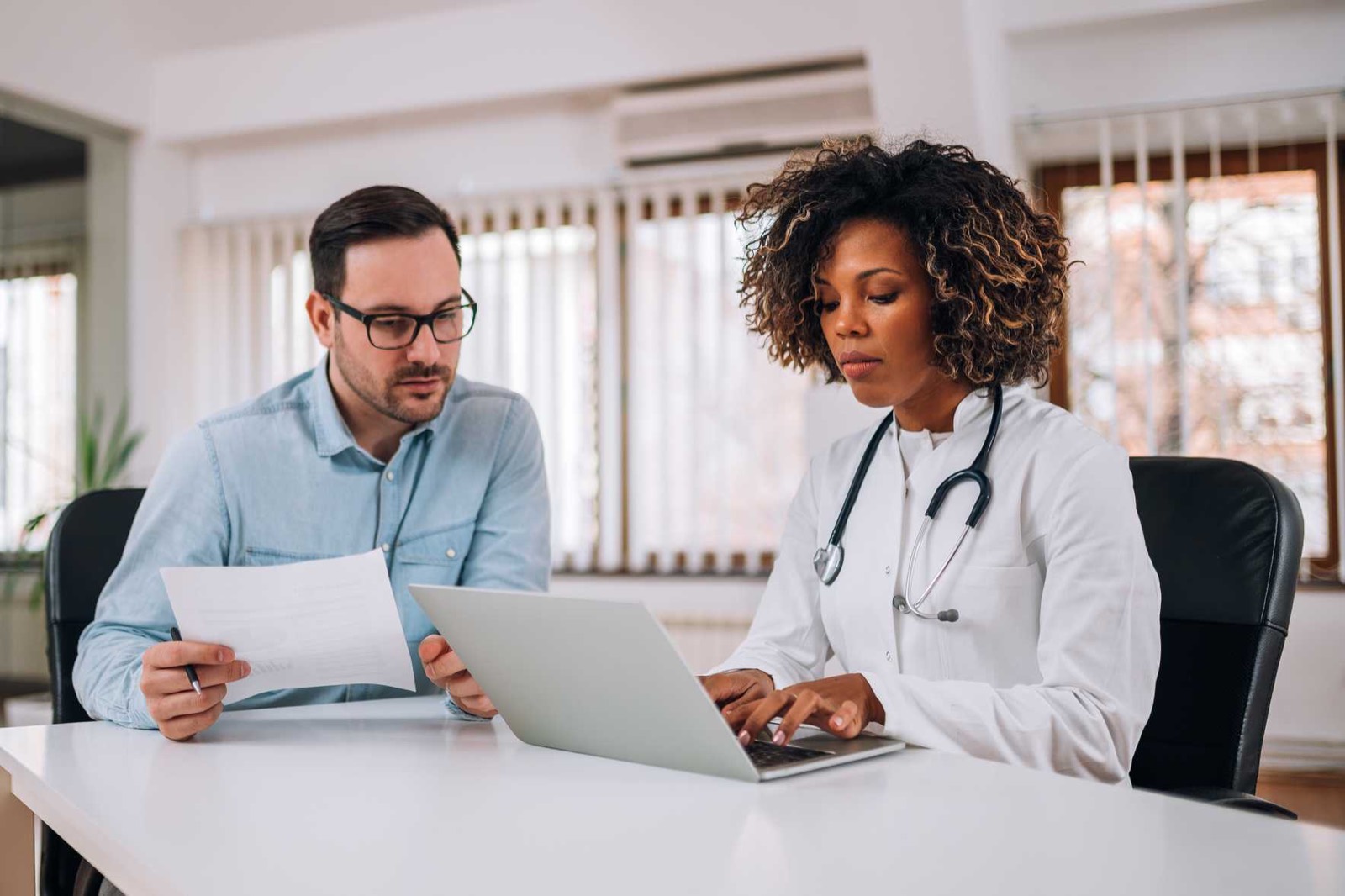 Médica revisando o acompanhamento do paciente com apoio de sistema de gestão